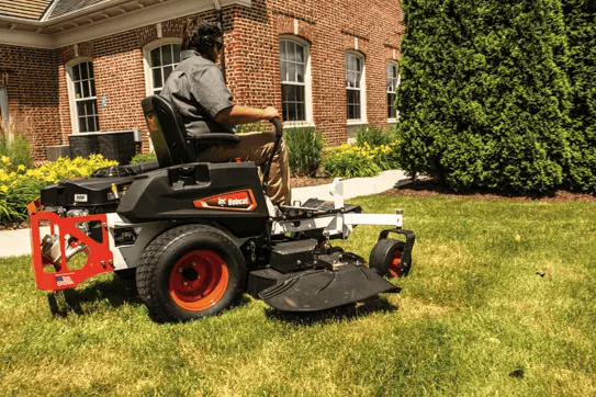 A man confidently rides a black and red Bobcat® ZT2000 lawn mower with a 48” deck in Greenville, NY.