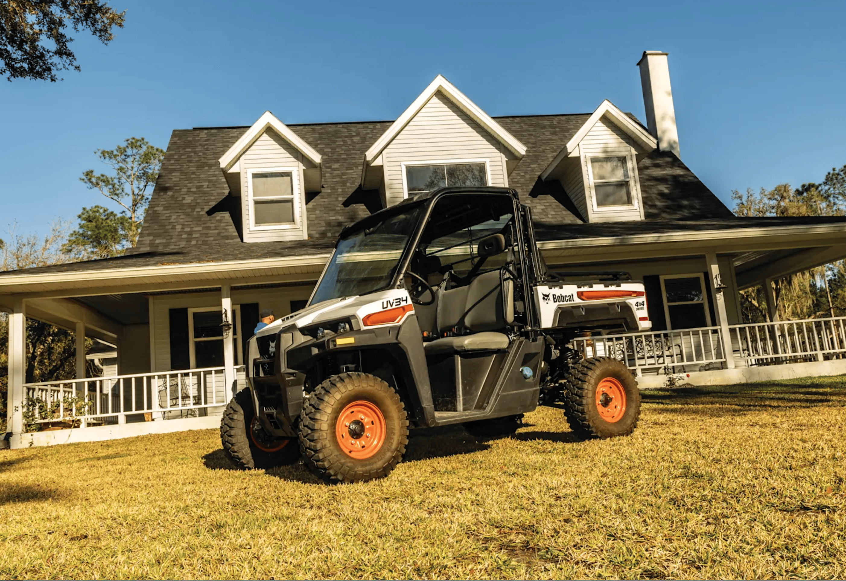 The 2024 Bobcat® Utility Vehicle UV34 Diesel is parked outside a charming home, ready for work or adventure.