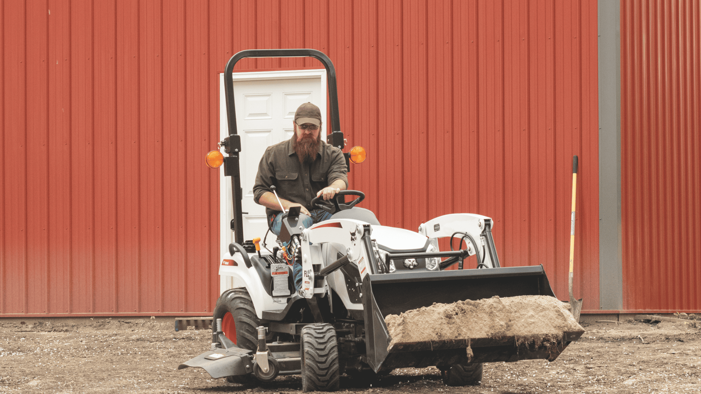 A man drives the 2025 Bobcat® CT1025 Sub-Compact Tractor across a dirt field in Greenville, NY.