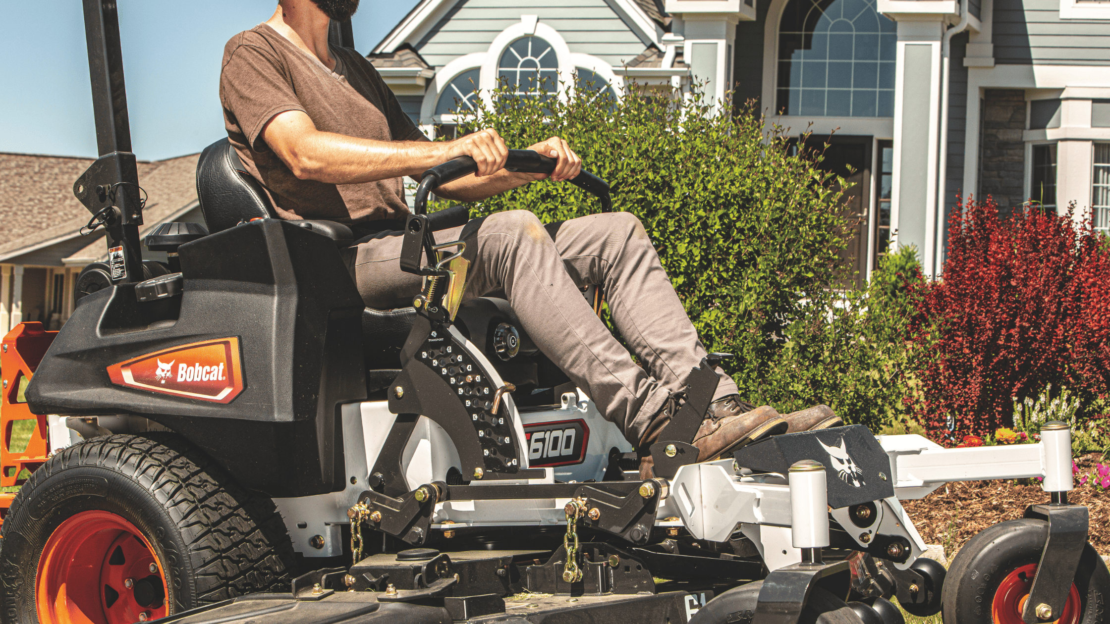 In Greenville, NY, a man expertly maneuvers a black and red Bobcat® ZT6100 Zero-Turn Mower, highlighting its efficiency and style.